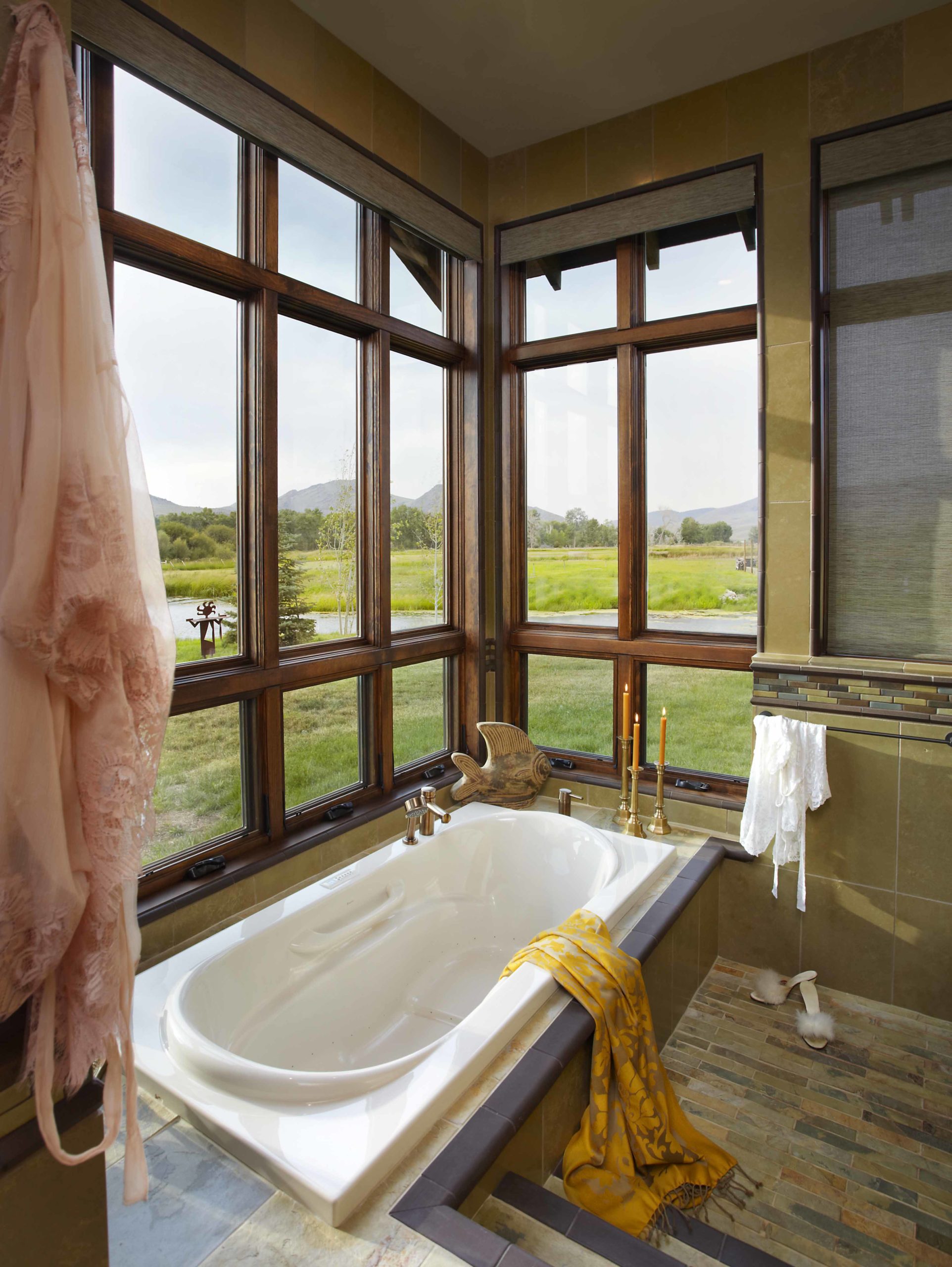 Close up of bathtub in front of a corner of windows