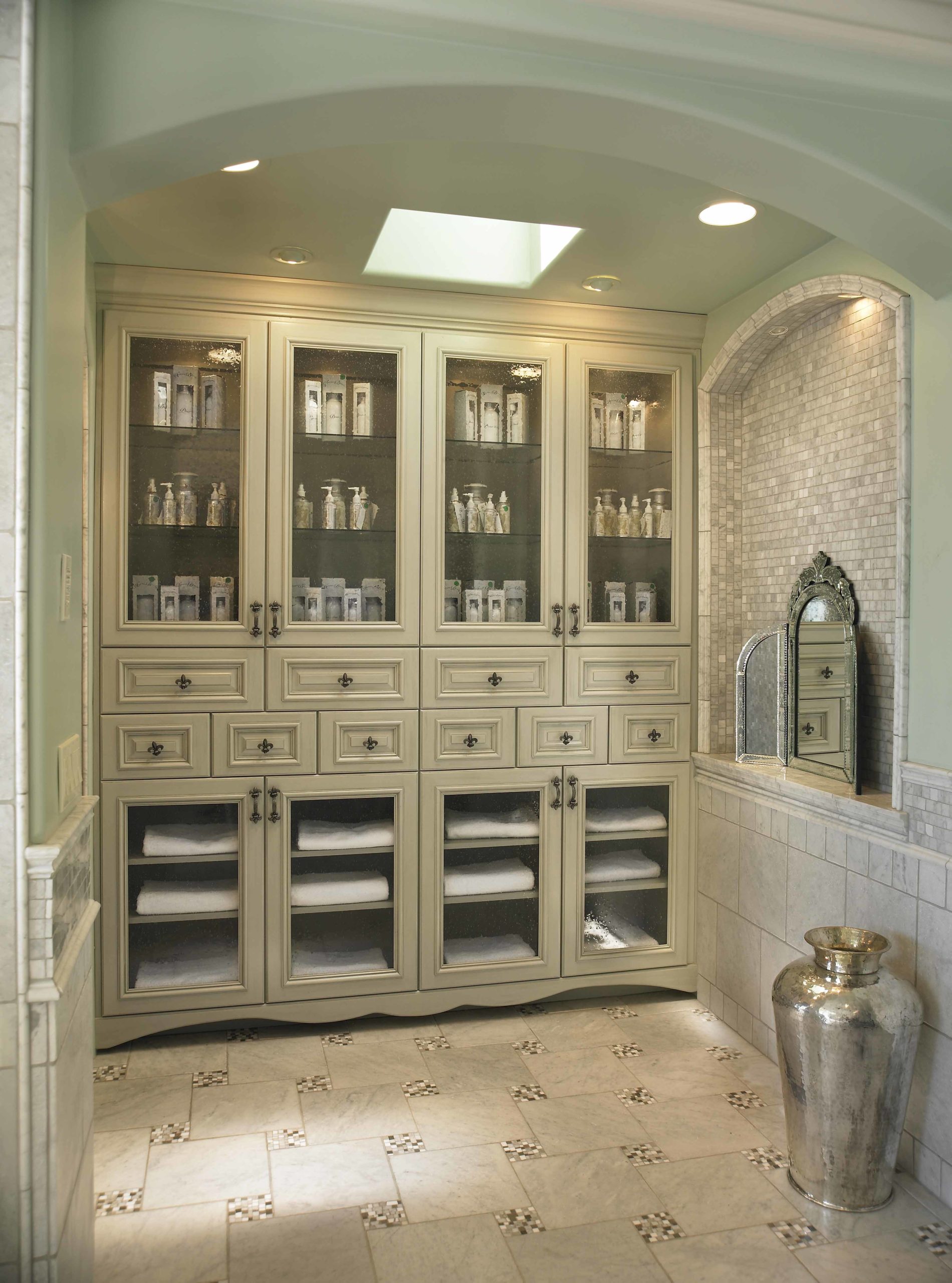 Bathroom storage in cream cabinets lining a wall with tiled floors