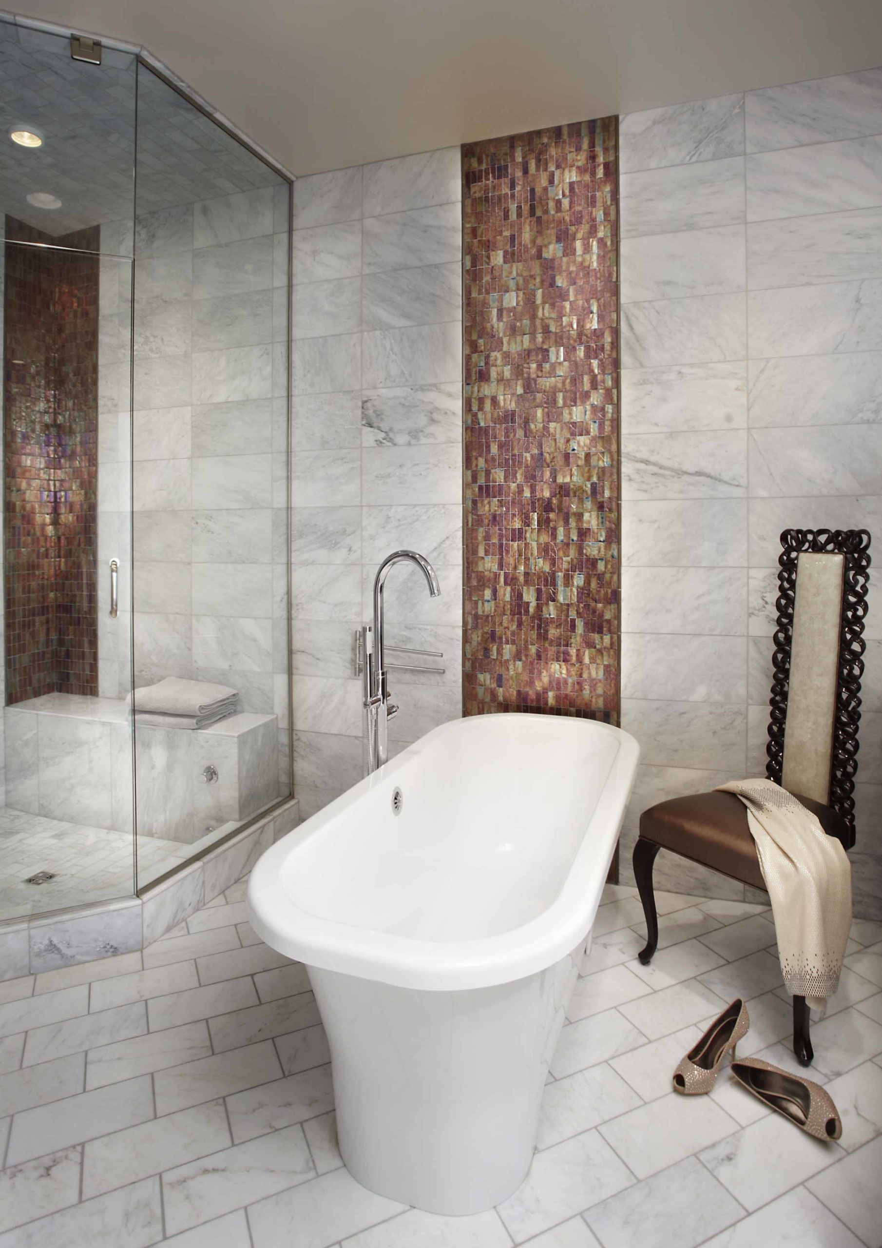 Tub in the middle of a bathroom with white tiled floors and walls