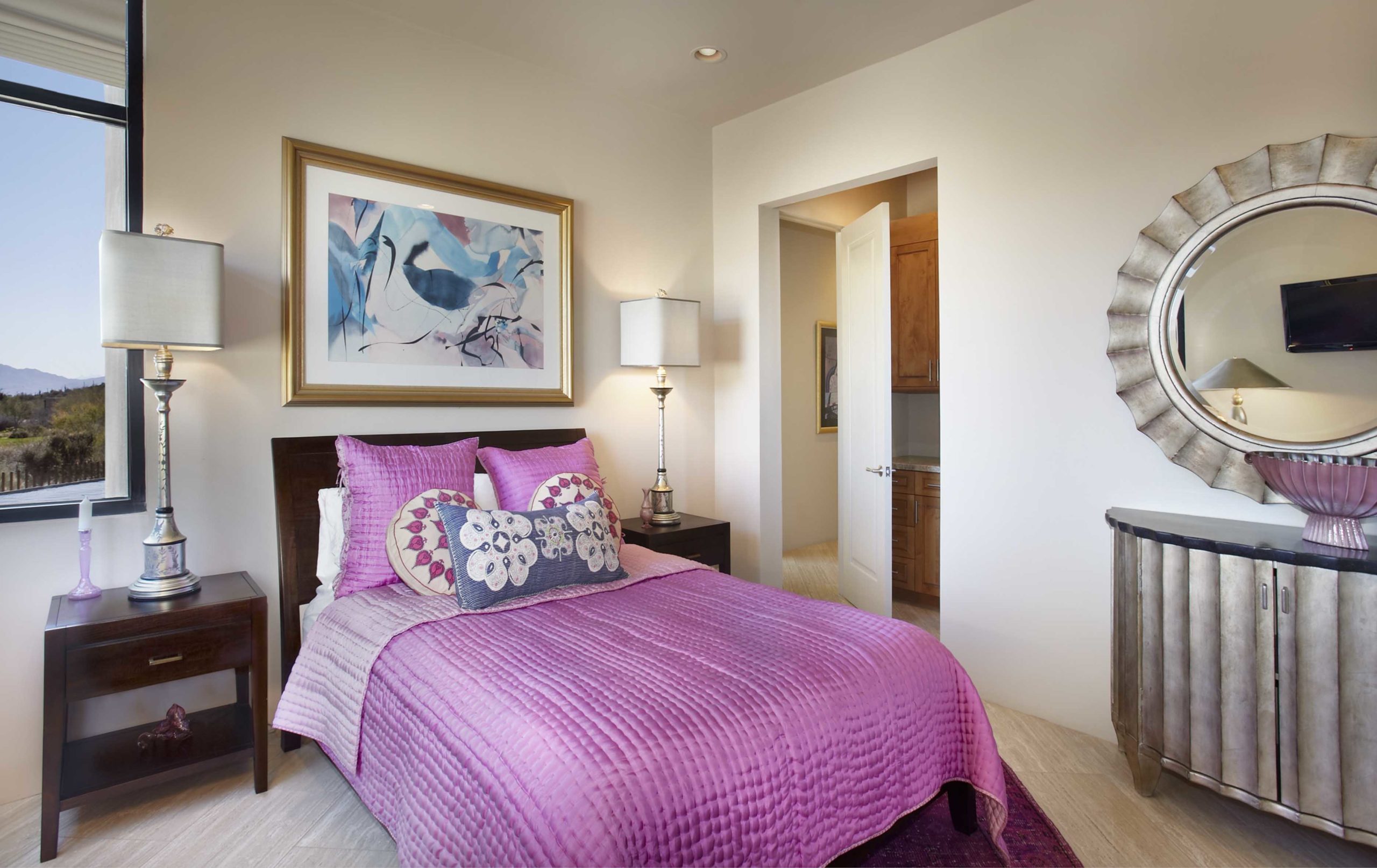 Bedroom with white walls and a bright purple comforter on the bed
