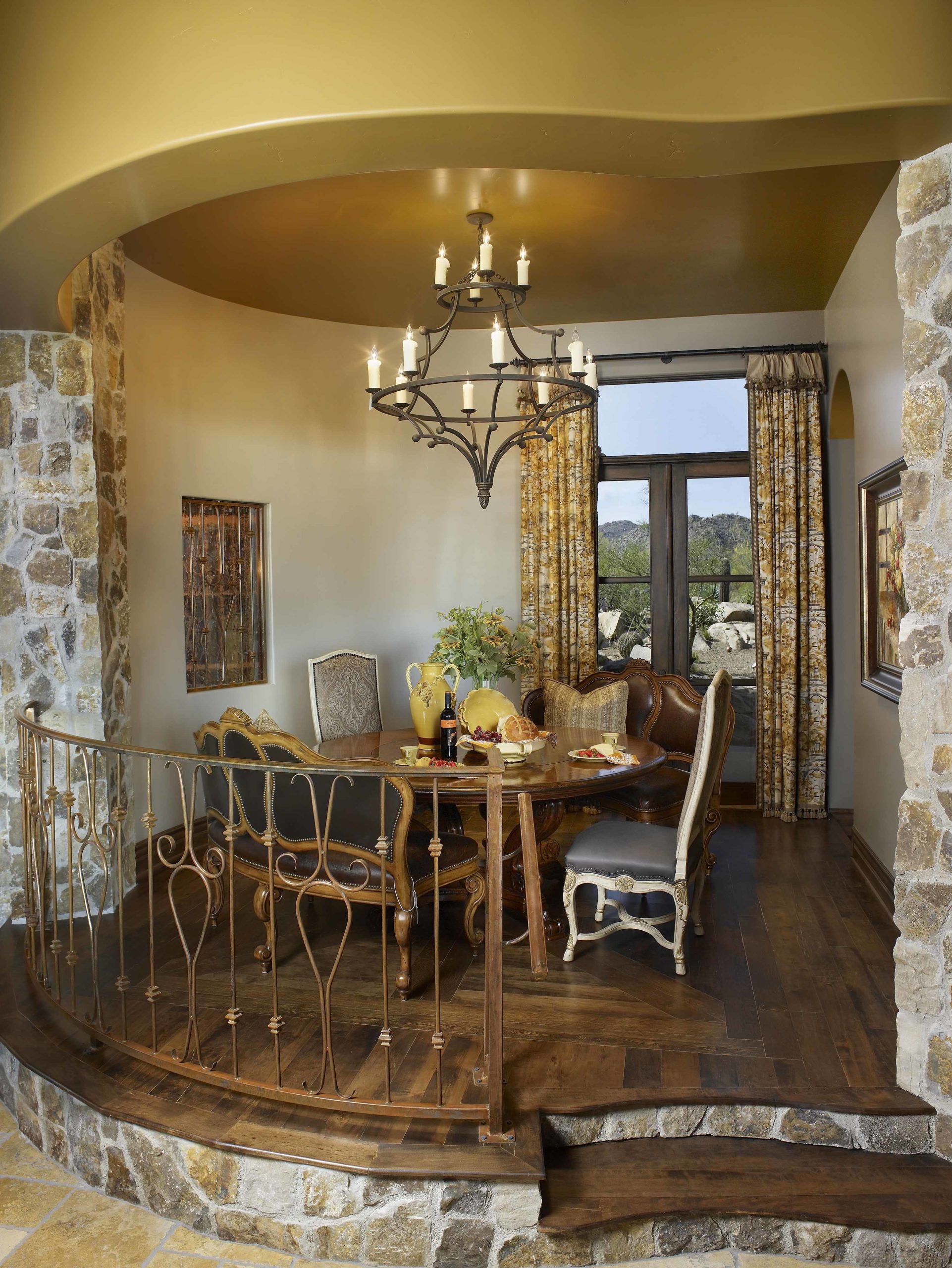 Small dining room up a couple stairs with stone wall accents in front of a window