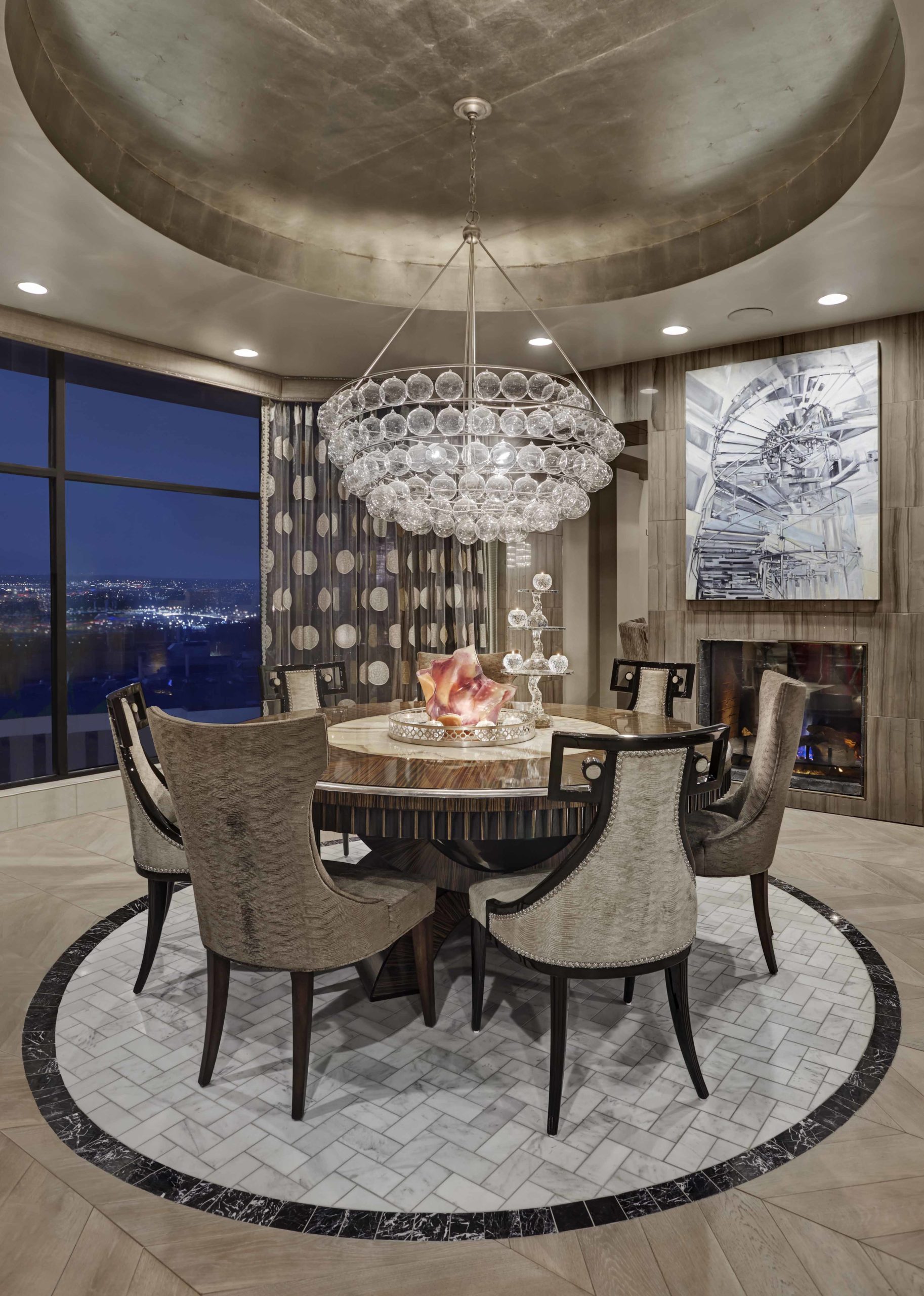 Dining room with round table and big chandelier hanging over the table