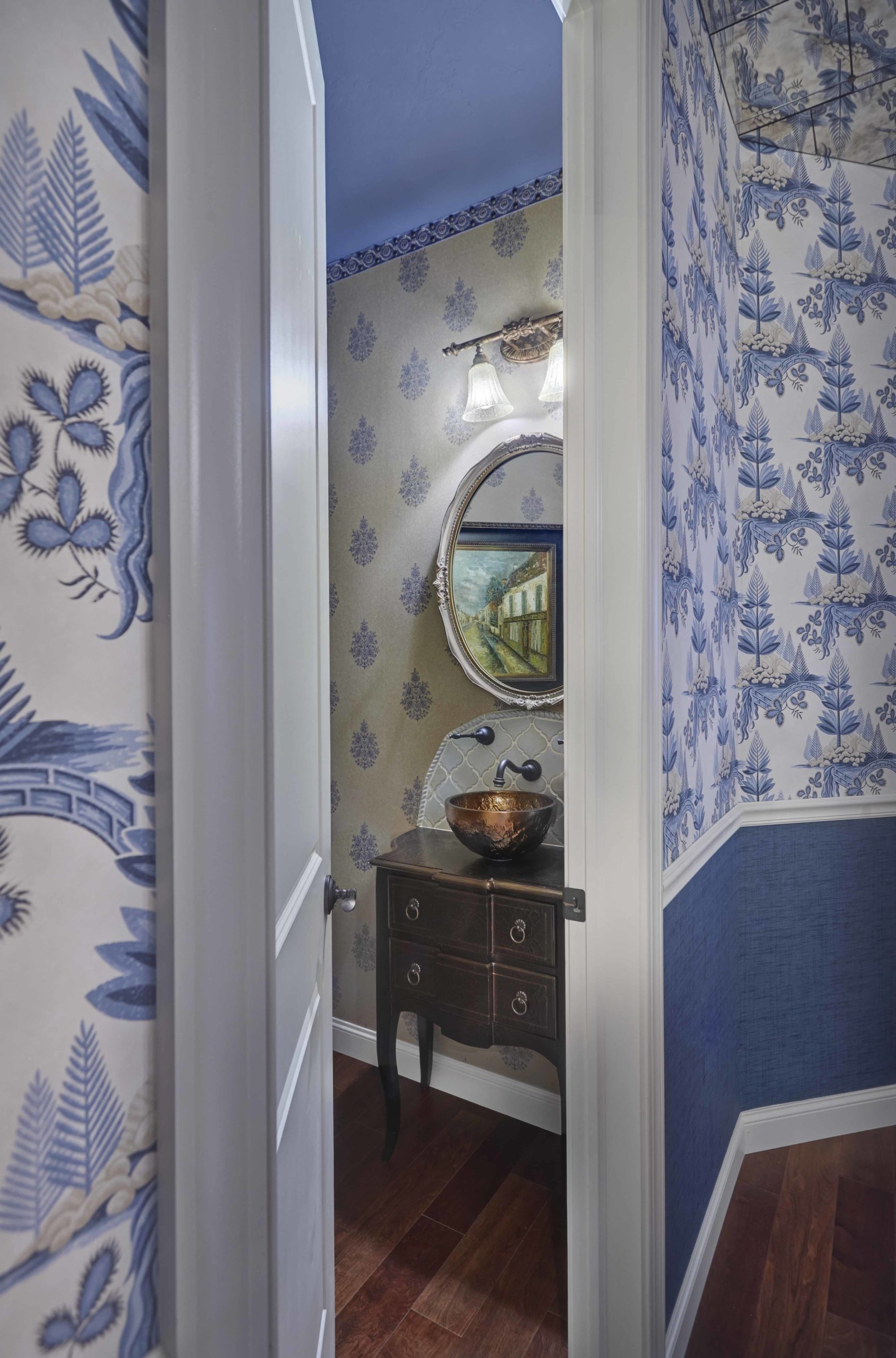 Close up of walls with blue and white wallpaper and a white door opening