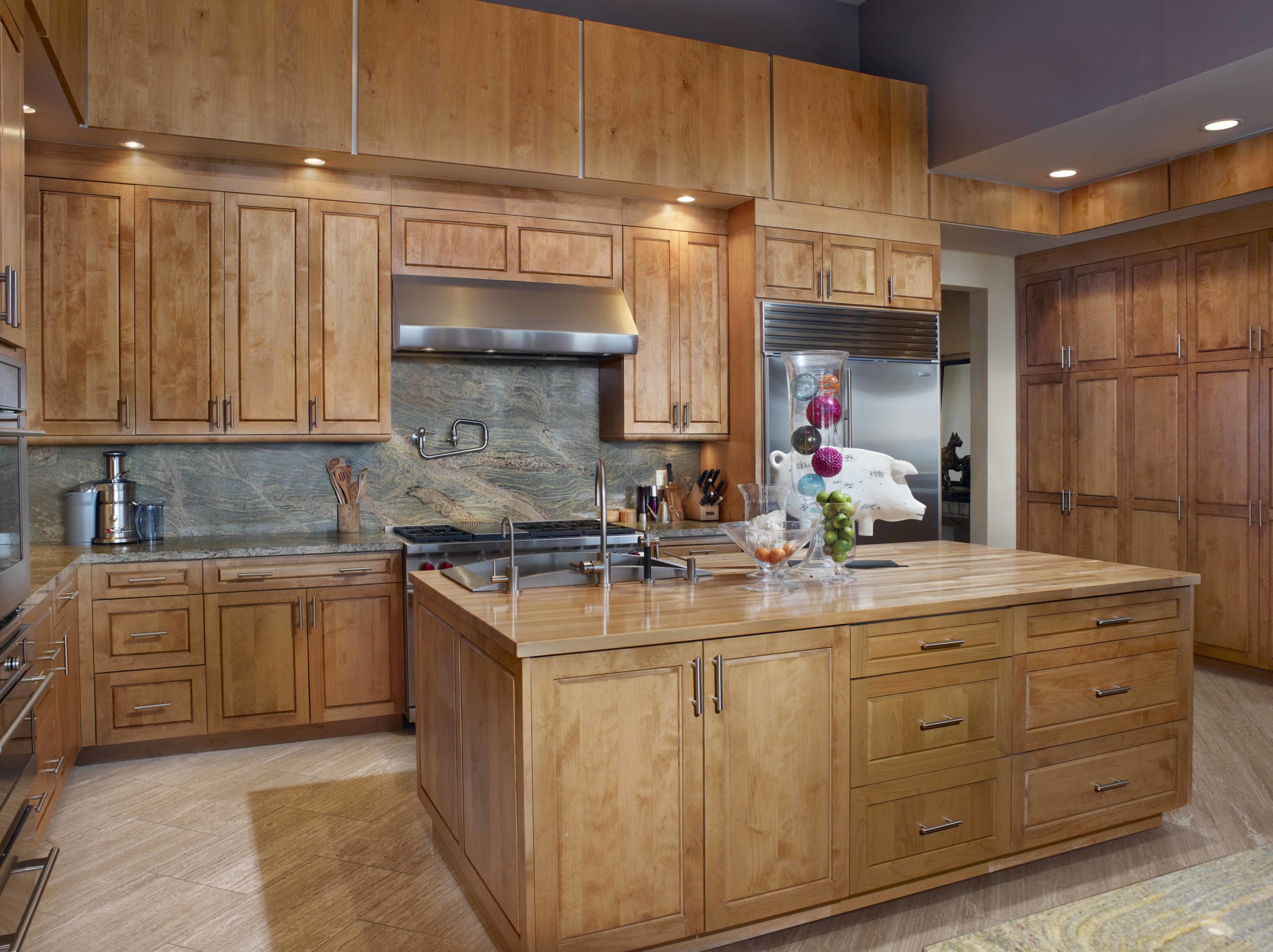 Tall wooden cabinets with stone backsplash