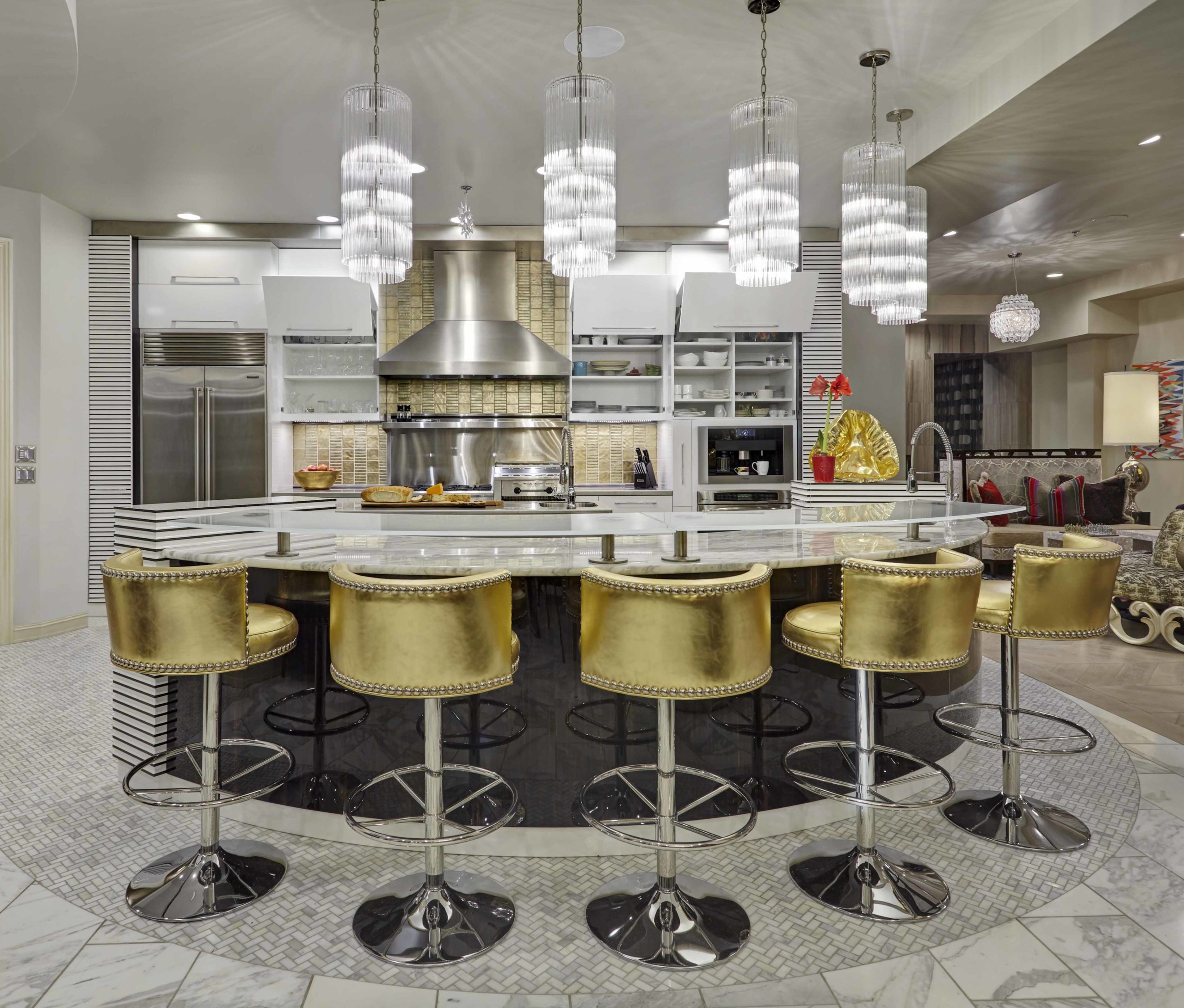 Kitchen with five chandelier hanging over the island with golden island barstools