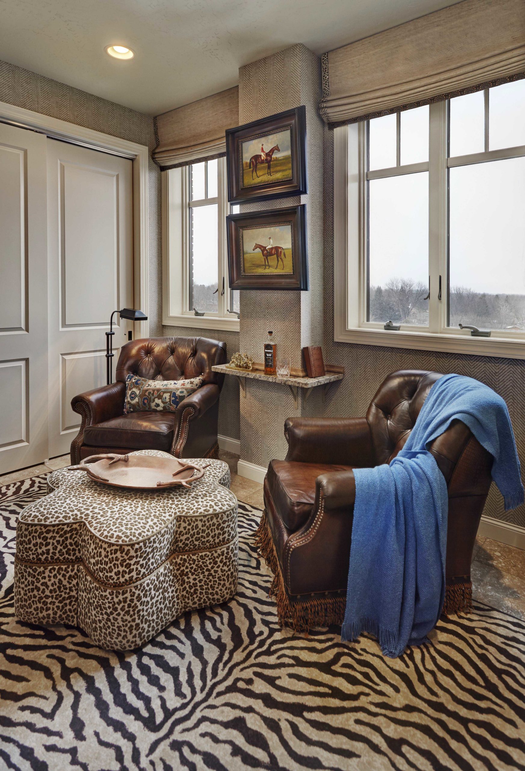 Corner of room with brown leather chairs and zebra rug